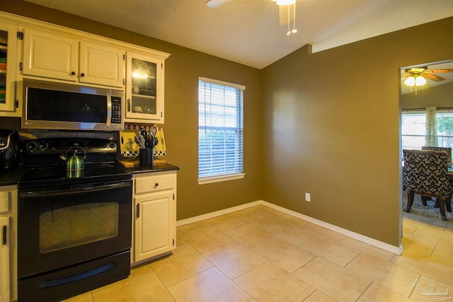 kitchen featuring white cabinetry, a wealth of natural light, ceiling fan, and black range with electric cooktop