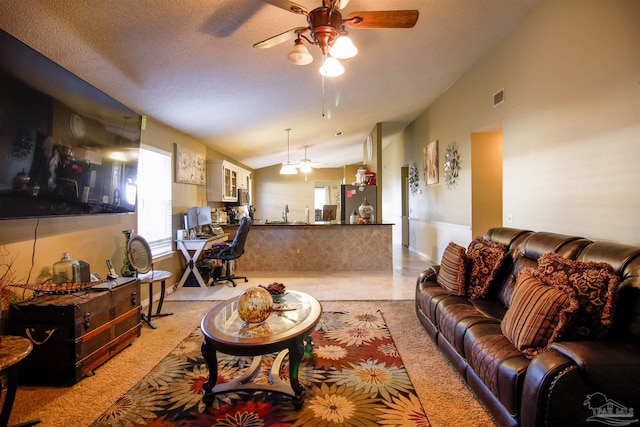 living room with ceiling fan, lofted ceiling, a textured ceiling, and light tile patterned floors