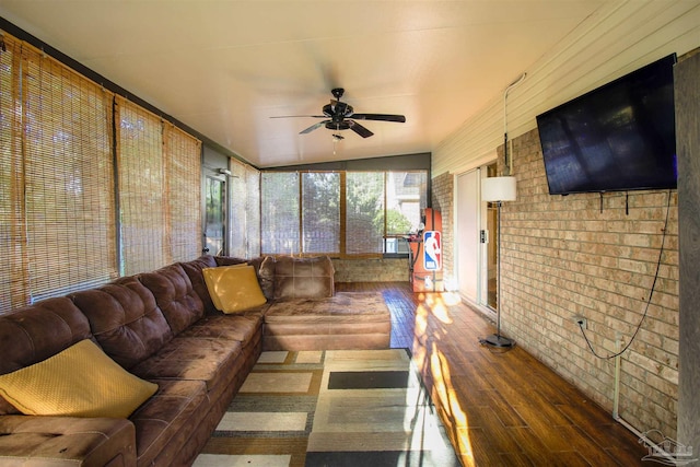 living room with hardwood / wood-style flooring, brick wall, and ceiling fan