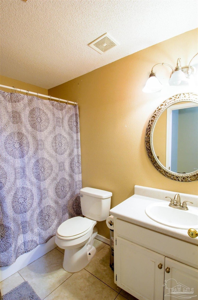 bathroom with tile patterned floors, toilet, a textured ceiling, and vanity