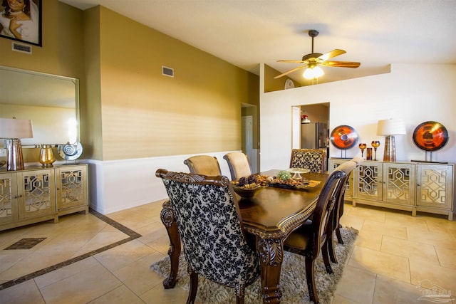 tiled dining space with ceiling fan and vaulted ceiling