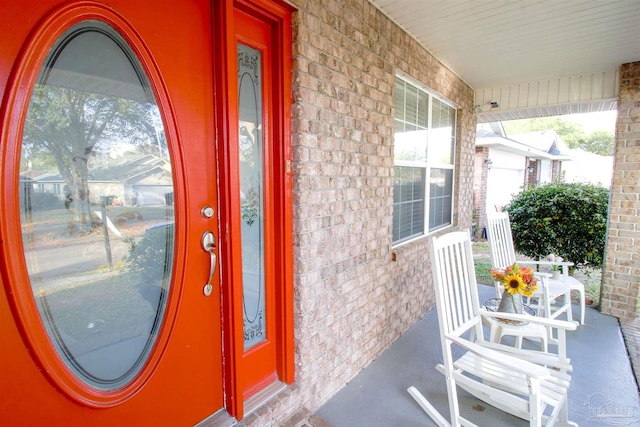 view of exterior entry featuring covered porch