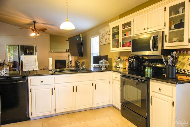 kitchen with sink, black appliances, dark stone countertops, pendant lighting, and white cabinets