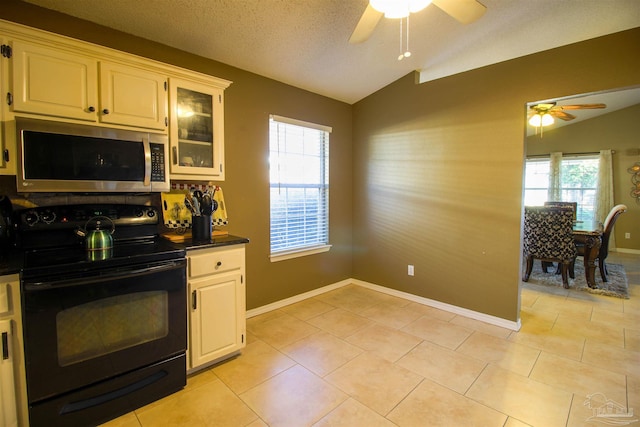 kitchen with black range with electric stovetop, lofted ceiling, light tile patterned floors, and ceiling fan