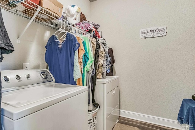 laundry room featuring washing machine and clothes dryer and hardwood / wood-style floors