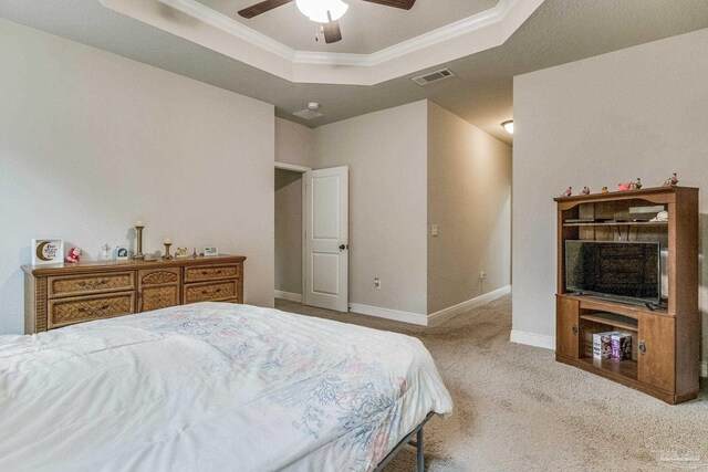 bedroom featuring ceiling fan, a raised ceiling, light carpet, and crown molding