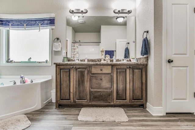 bathroom with hardwood / wood-style floors, vanity, and independent shower and bath