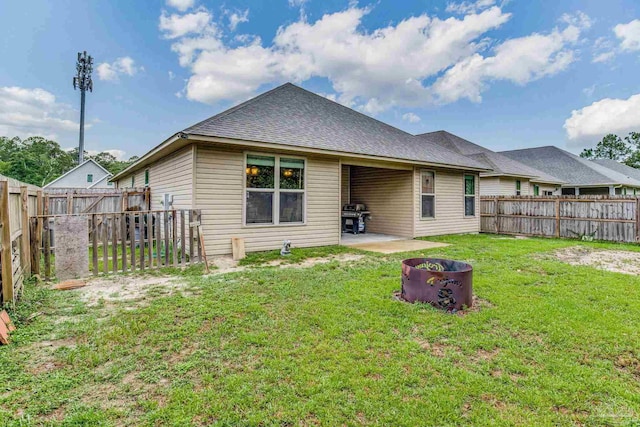 back of house with a yard and a patio