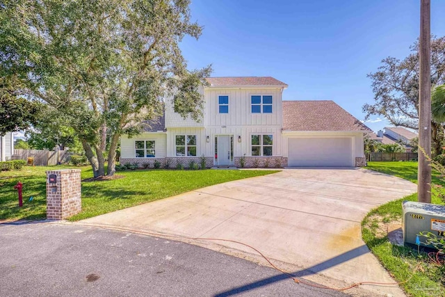 view of front of home with a garage, fence, a front lawn, and board and batten siding