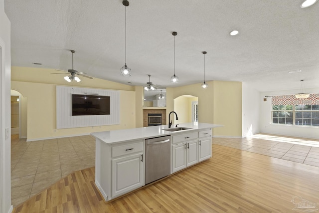 kitchen with dishwasher, light hardwood / wood-style floors, a center island with sink, and sink