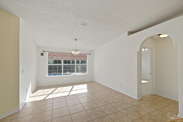 tiled spare room with a textured ceiling