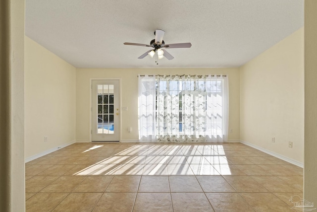 tiled spare room featuring a textured ceiling and ceiling fan