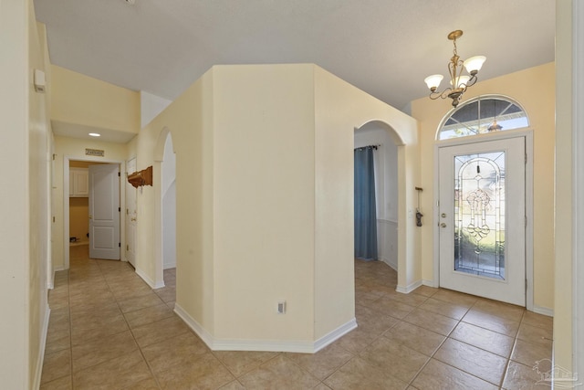 foyer entrance with a notable chandelier and light tile patterned flooring