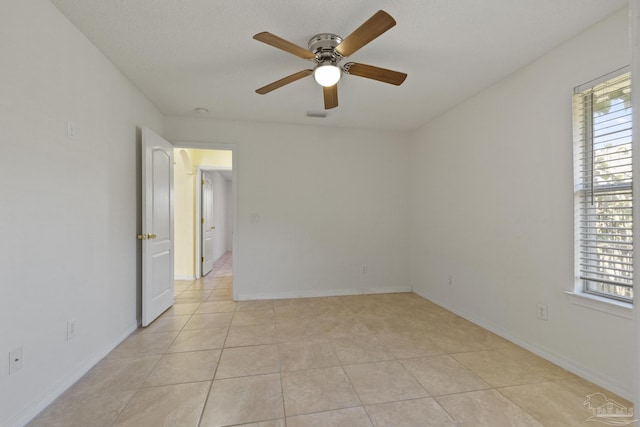 spare room featuring ceiling fan and light tile patterned flooring