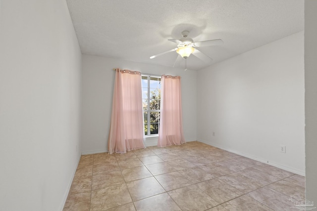 tiled spare room with a textured ceiling and ceiling fan