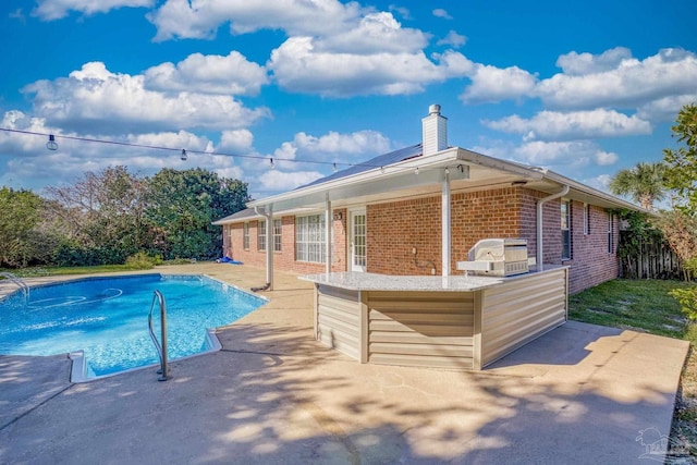 view of swimming pool with a grill and a patio