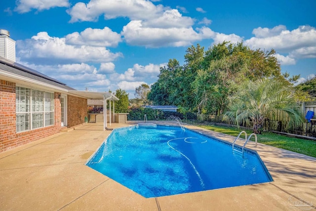 view of swimming pool with pool water feature and a patio