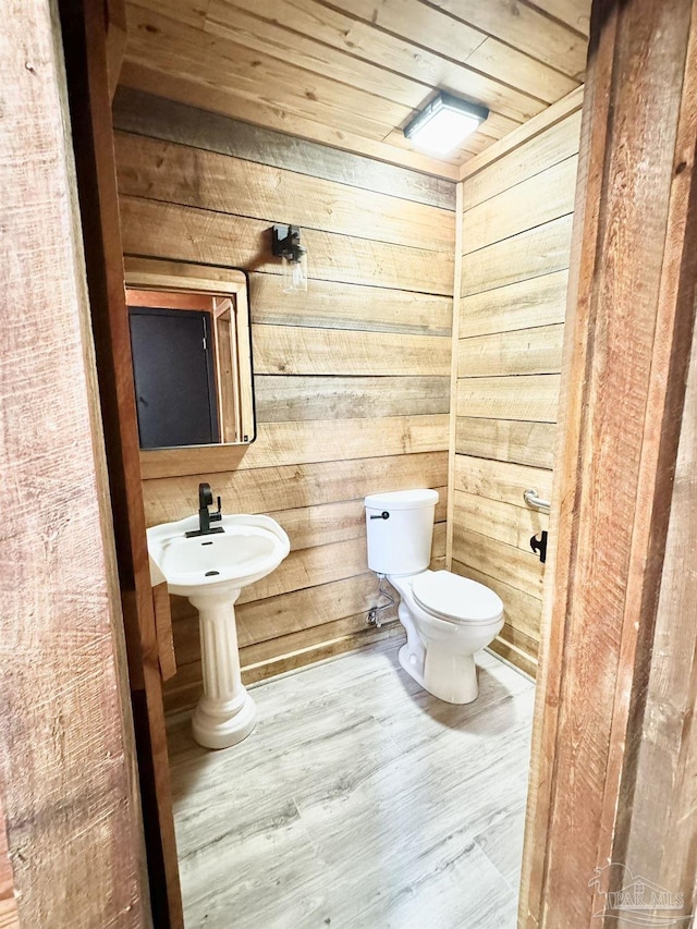 bathroom featuring toilet, wood-type flooring, wooden walls, and wooden ceiling