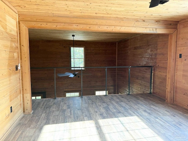 empty room with wooden walls, hardwood / wood-style floors, and wood ceiling