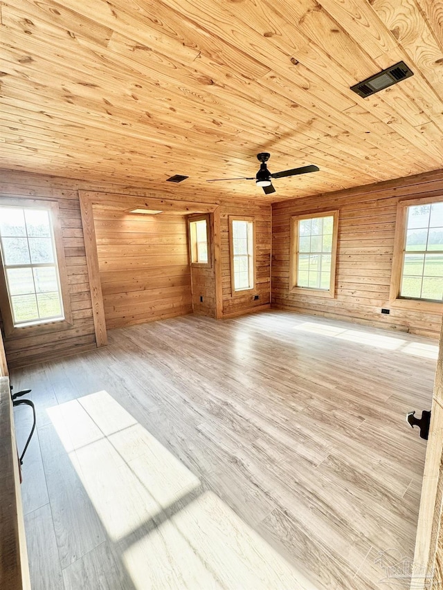 spare room with light hardwood / wood-style floors, wood ceiling, and a wealth of natural light