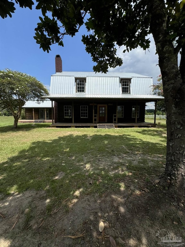 back of property with a yard and a porch