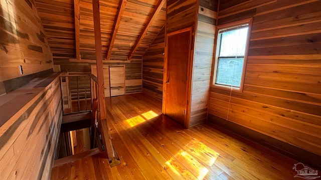 additional living space with vaulted ceiling with beams, wood-type flooring, wood ceiling, and wood walls