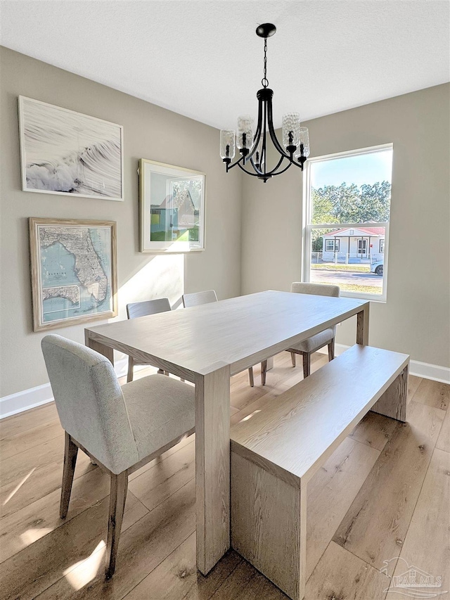 dining area with a chandelier and light wood-type flooring