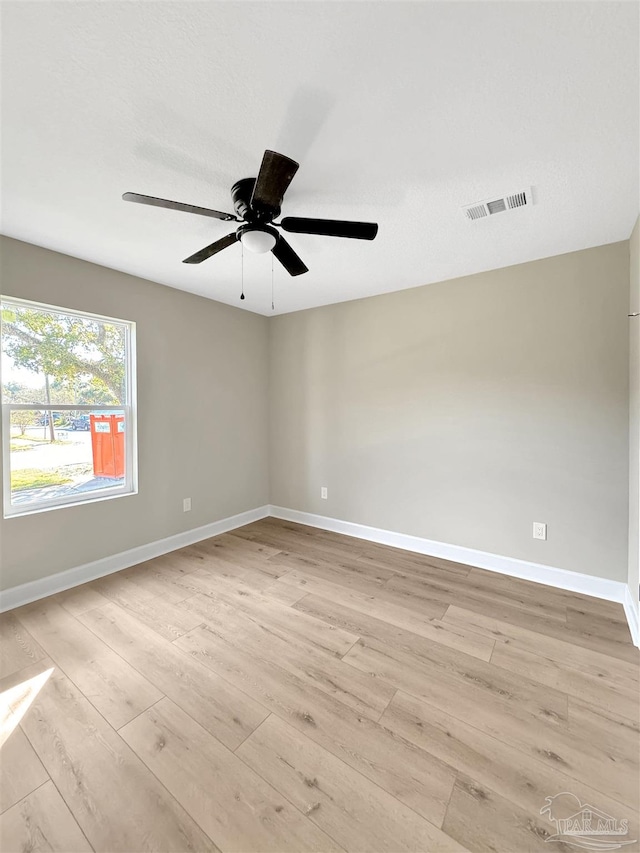 spare room with ceiling fan and light wood-type flooring