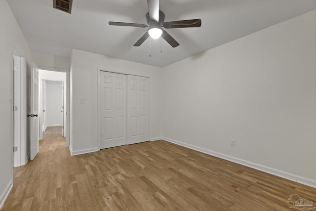 unfurnished bedroom featuring a closet, light hardwood / wood-style flooring, and ceiling fan