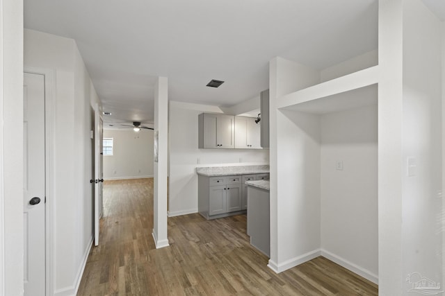 kitchen with wood-type flooring, gray cabinets, and ceiling fan