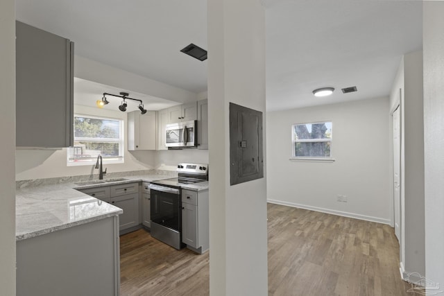 kitchen with electric panel, stainless steel appliances, a wealth of natural light, and sink