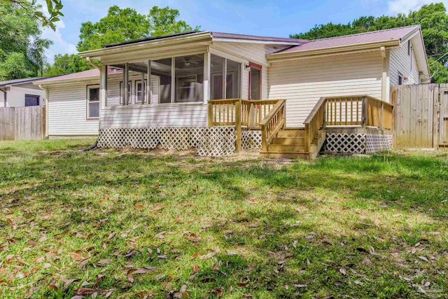 7035 Moore Ave, Pensacola, FL 32526 - back of house with fence, a sunroom, a deck, and a lawn