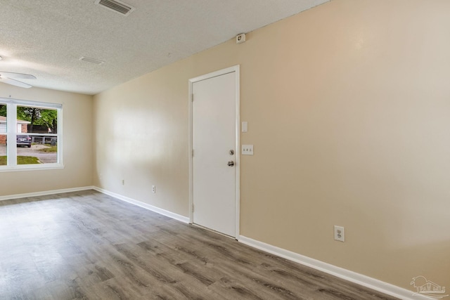 7035 Moore Ave, Pensacola, FL 32526 - empty room with wood finished floors, a textured ceiling, visible vents, ceiling fan, and baseboards