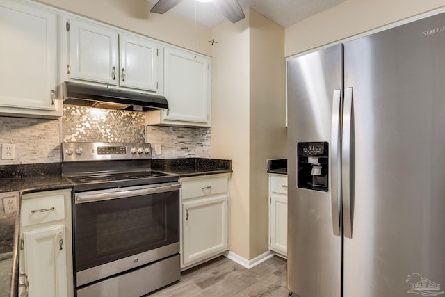 7035 Moore Ave, Pensacola, FL 32526 - kitchen with light wood finished floors, stainless steel appliances, white cabinetry, under cabinet range hood, and tasteful backsplash