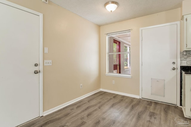 7035 Moore Ave, Pensacola, FL 32526 - entryway with baseboards, light wood-style flooring, and a textured ceiling