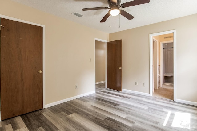 7035 Moore Ave, Pensacola, FL 32526 - unfurnished bedroom with a ceiling fan, connected bathroom, visible vents, and wood finished floors