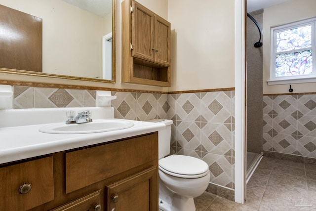 7035 Moore Ave, Pensacola, FL 32526 - full bath with tile walls, toilet, a shower stall, vanity, and a wainscoted wall