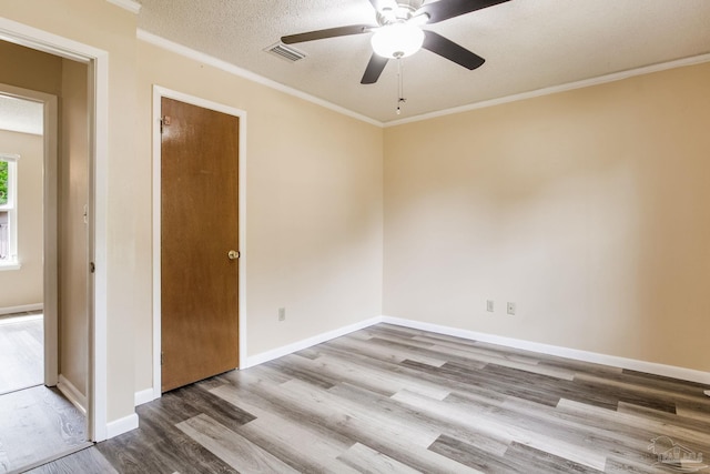 7035 Moore Ave, Pensacola, FL 32526 - spare room featuring wood finished floors, a ceiling fan, visible vents, baseboards, and ornamental molding