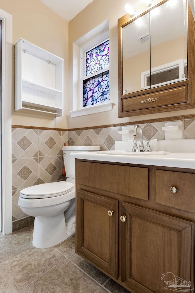 7035 Moore Ave, Pensacola, FL 32526 - bathroom with tile walls, toilet, wainscoting, and vanity