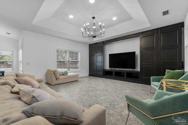 living room featuring an inviting chandelier, plenty of natural light, and a tray ceiling