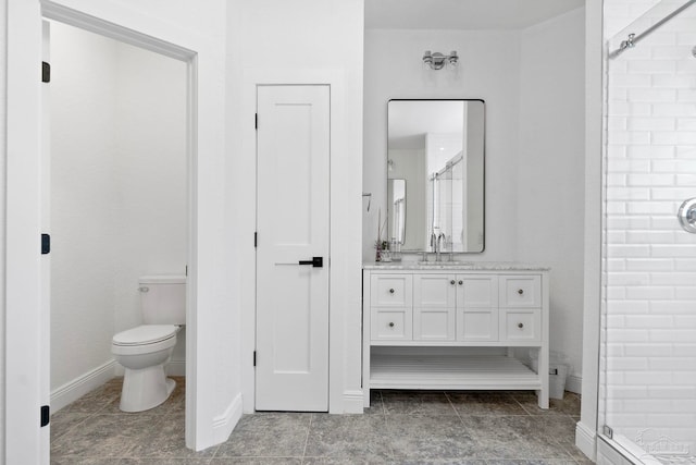 bathroom with a shower with door, vanity, and toilet