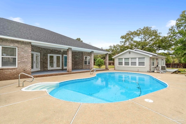 view of swimming pool featuring french doors and a patio area