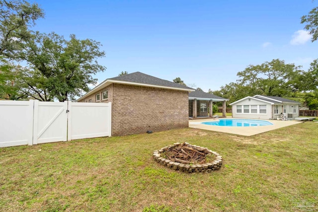 view of yard featuring an outdoor fire pit, a patio area, and a fenced in pool