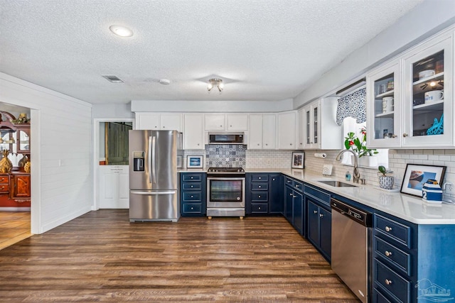 kitchen featuring dark wood-type flooring, stainless steel appliances, sink, blue cabinets, and white cabinetry