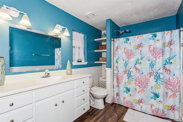 bathroom with vanity, toilet, a textured ceiling, and hardwood / wood-style floors