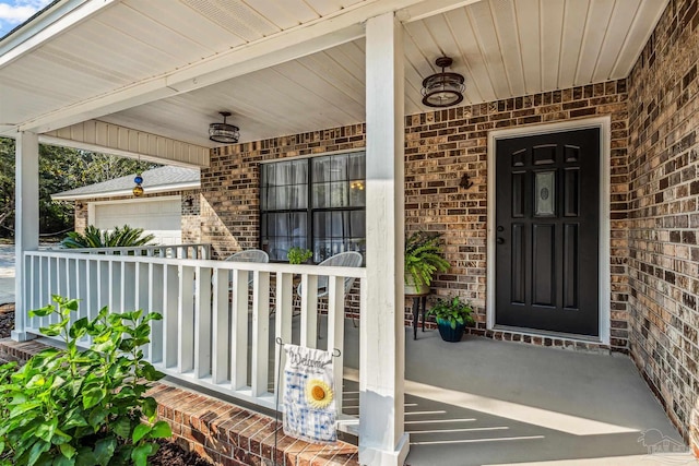 property entrance with covered porch and a garage