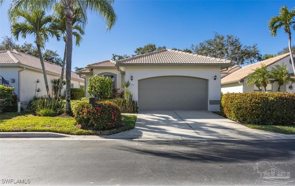 176 Vista Ln, Naples, FL 34119 - mediterranean / spanish house with a tiled roof, an attached garage, stucco siding, and concrete driveway
