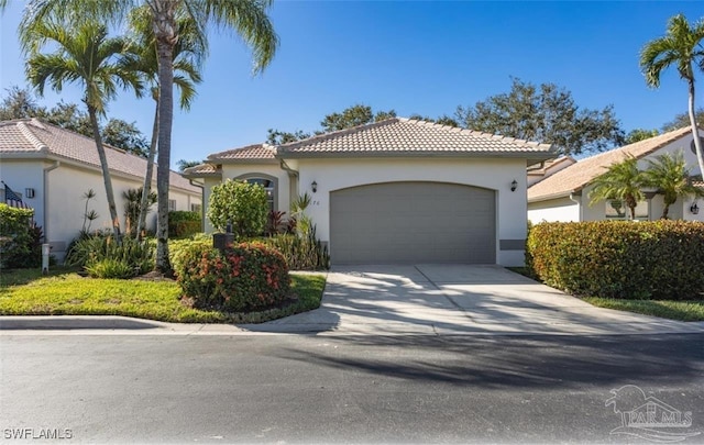 176 Vista Ln, Naples, FL 34119 - mediterranean / spanish house with a tiled roof, an attached garage, stucco siding, and concrete driveway