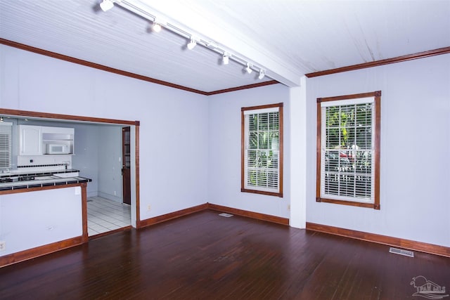 unfurnished living room with hardwood / wood-style floors, crown molding, and rail lighting