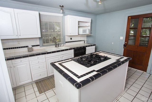 kitchen with tile countertops, sink, a kitchen island, and white cabinets